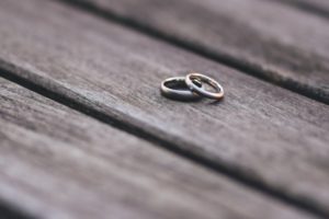 Close up of two wedding rings on wooden bench